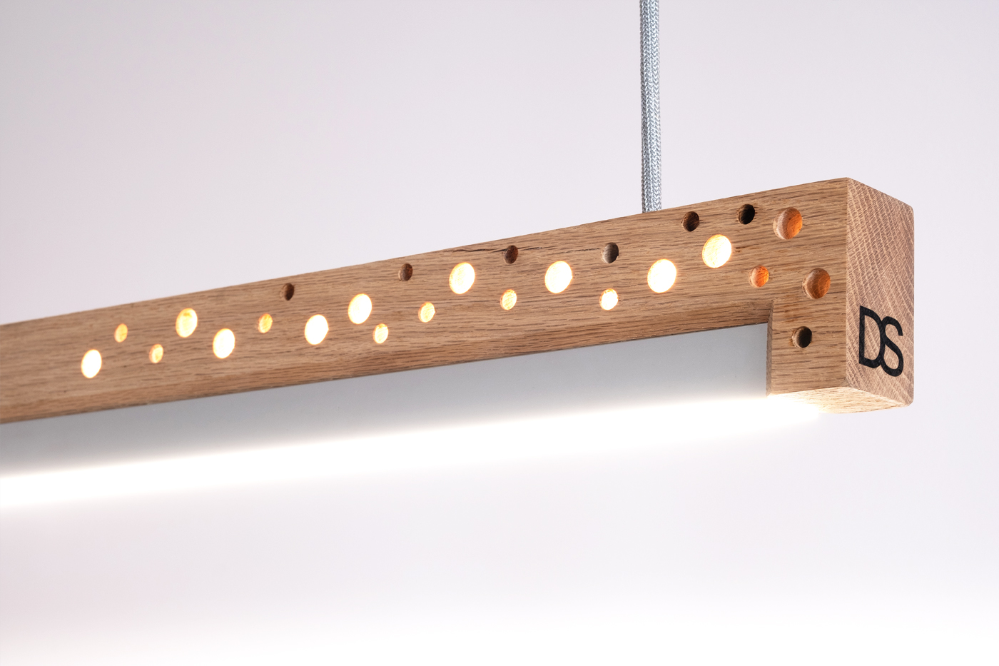 Otvory v dřevěném těle svítidla jsou jak estetický, tak i funkční detail.